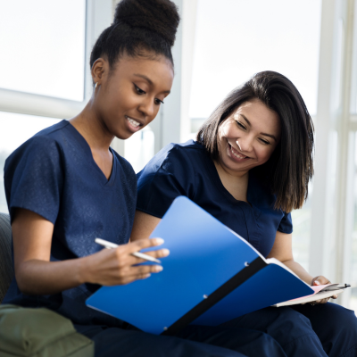 Two medical professionals looking at a notebook