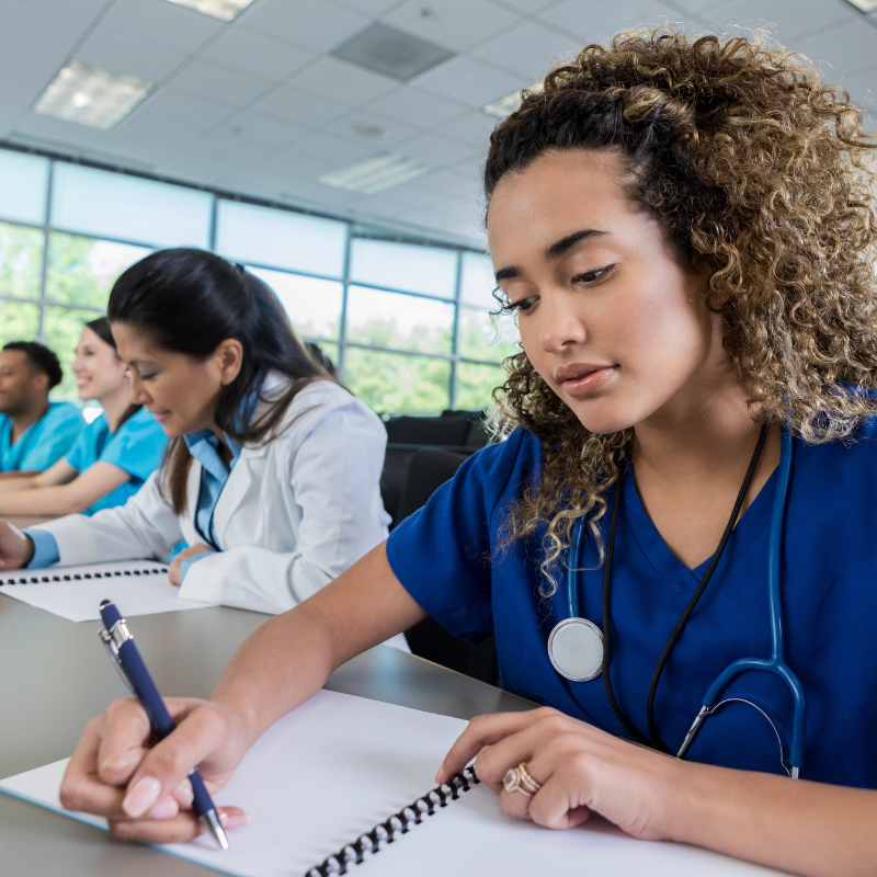 a female medical professional writing in a notebook